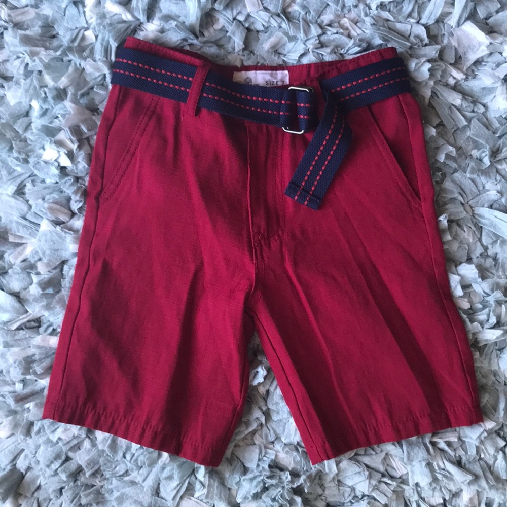 Boys red shorts with navy belt.